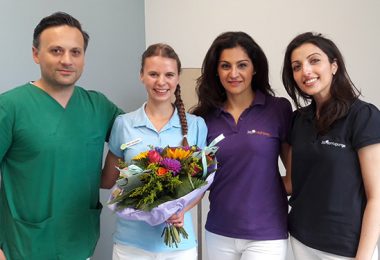Zahnmedizinische Fachangestellte Malin mit Blumenstrauss und Team