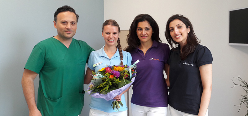 Zahnmedizinische Fachangestellte Malin mit Blumenstrauss und Team