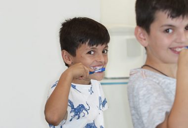 Jungs mit Zahnspange putzen Zähne